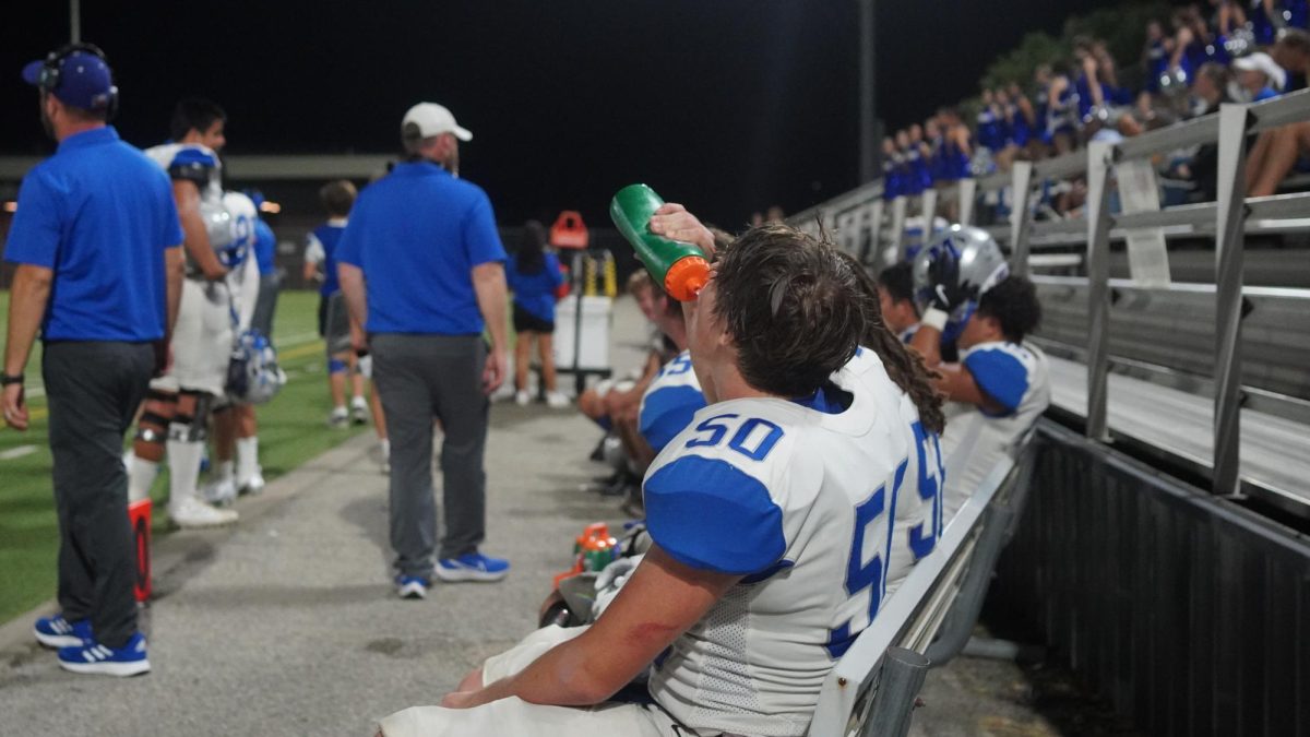 Starting right tackle senior John Scott Mabry hydrates while the McCallum Knights run an offensive play during their game against Dallas Pinkston on Sept 13.