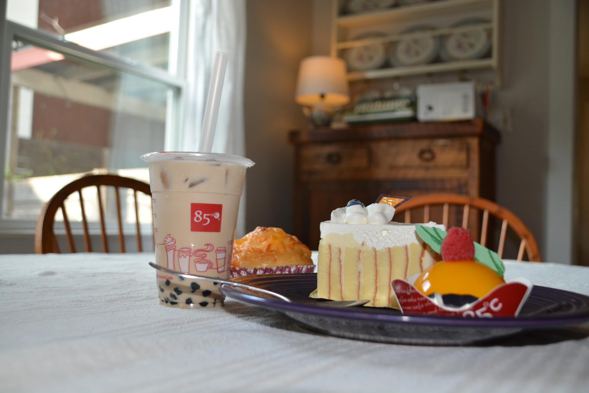 A variety of offerings from 85 Degrees Celsius: milk tea with boba, lemon cake, cheese roll and a "Mango Delight" mousse. 