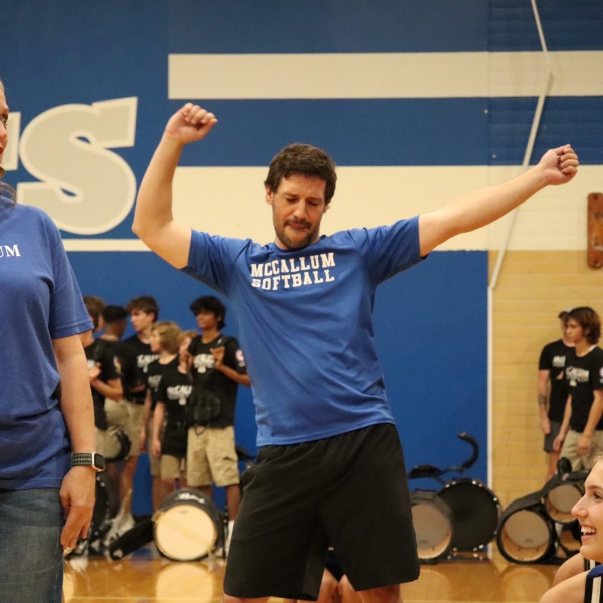 STOCKTON SLAYS: Vaughn Stockton puts his hands up and shimmies at Friday’s pep rally, where a group of teachers performed a dance routine. 

The yearly teacher pep rally and dance took place before the game against Elgin. In preparation for the performance, the teachers were invited to join by cheerleaders and rehearsed the routine after school. Stockton, a history and debate teacher, decided to take part and join the practices.

“The cheerleaders led us through small parts of the dance and then gradually we built up the entire dance with the cheerleaders demonstrating and then correcting our mistakes,” Stockton said. 

 The teachers' hard work paid off as they were able to perform their moves in front of the McCallum student body.

Stockton enjoyed the entire experience, but his favorite part was interacting with the other teachers in the dance. 

“My favorite was getting to bump hips with Ms. Sorto,” Stockton said.

Caption by Arwen Pelletier. 