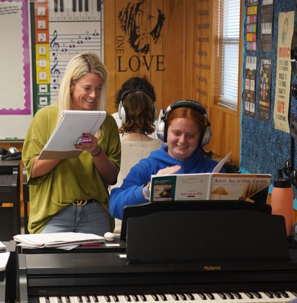 Piano teacher Kate Wiley checks on the progress of junior Harper Wade during seventh-period piano class on Oct. 24 in the piano portable.