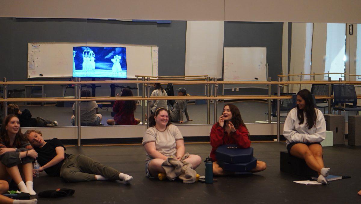 Senior Zoe Maxwell and Perla Vela laugh while they discuss and watch a recorded performance of professionals dancing in "The Nutcracker". Normally for this course, the students are analyzing and writing instead of dancing.