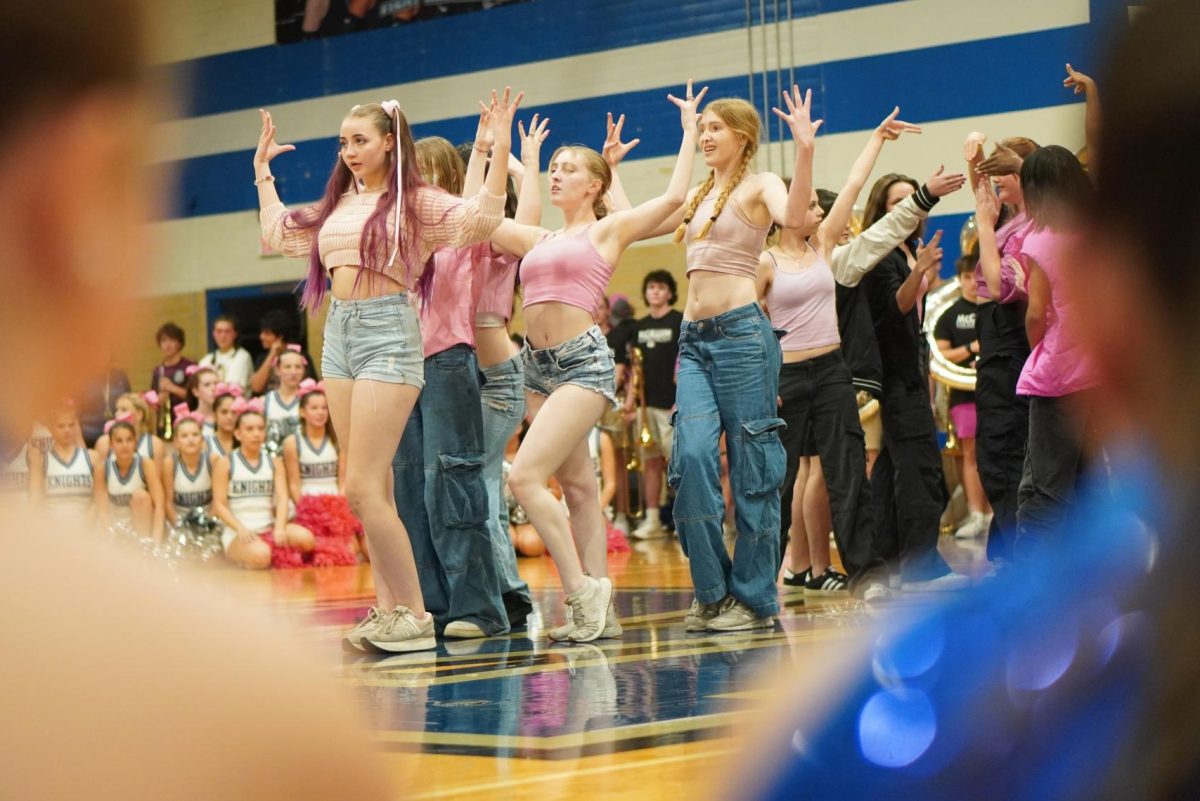 PINK AND BLU3: Aside from the normal Pink Week pep rally traditions, the pep rally also featured the pep rally debut of the Blu3 Dance Crew, the school's K-pop dance group.

“I think overall it went really well for our first big performance, especially with what happened with the music,” junior dance major and BLU3 member Ollie Roberts said. “I think we recovered from that very well.”

As Roberts mentioned, the music acted up multiple times during the troupe’s performance, cutting out the first part of the opening number, “Loco,” as well as the first half of the third dance, “Super.” BLU3 Dance Crew adapted quickly, however, jumping into the middle of “Super” in the right positions.

“I think we did really well,” sophomore and BLU3 member Kate Griesemer said. “I’m very proud of all of us because we were able to get back in sync together and everyone got to their spots when they realized the sound was back.”

Roberts credits part of BLU3’s ability to recover quickly from the music problems to their growth, both in experience and numbers. Since it was established last fall, BLU3 has grown from nine to 15 members and has taken on more challenging dances.

“Last year, I don’t think we wouldn’t have been able to (a) perform at a pep rally, and (b) have been able to recover so fast from the music mishap,” Roberts said. “I think that it would have been a very different performance if we did it last year, and I think we’ve grown a lot.”

Caption by Elizabeth Nation.

