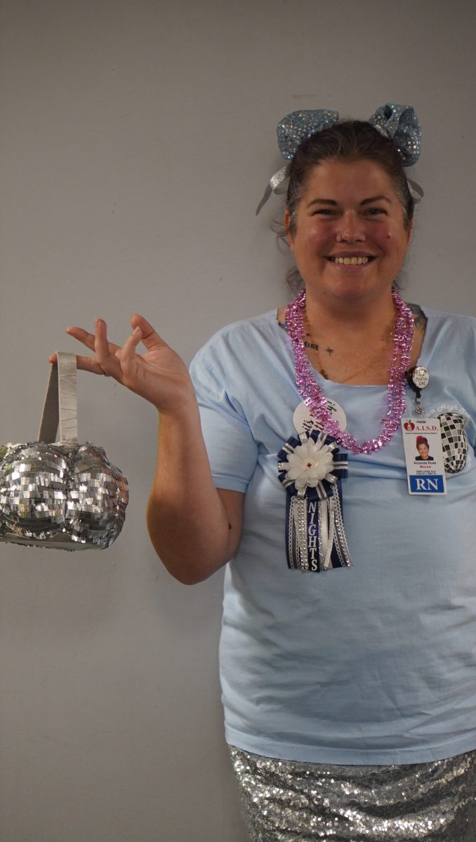 DECKED OUT: Decked out in disco spirit, school nurse Amanda Rose embraced every day of homecoming week, even creating her own disco ball accessory to match the theme on disco day, Oct. 18.  

Rose said her favorite part was crafting glittery space buns and making her DIY costume that shined all week long. Although she missed the homecoming game, she made the most of Spirit Week in style.

Caption by V Overstreet.