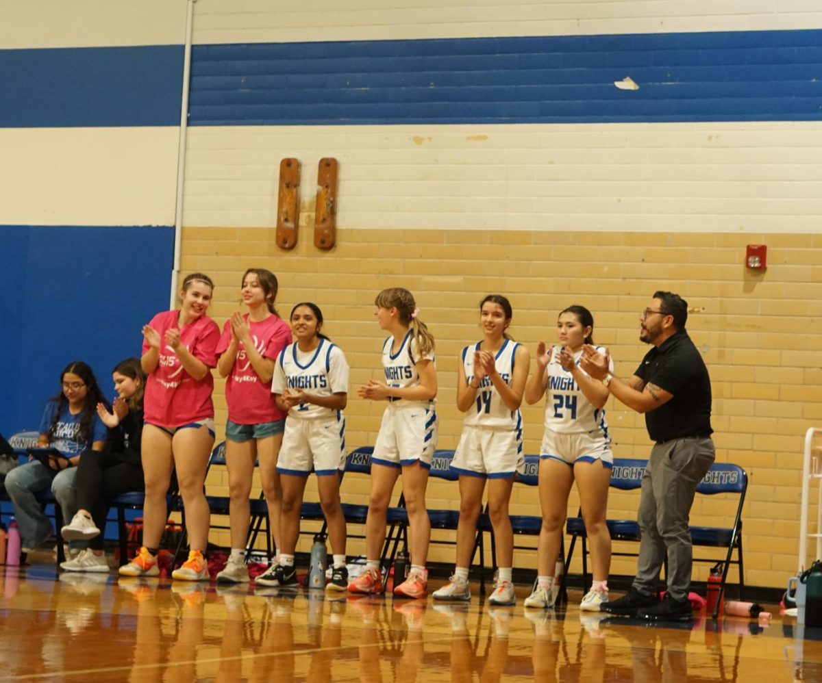 Senior Sonya Peterson stands alongside her teammates, cheering them on, during their game against the Manor Mustangs last year on Nov 23.