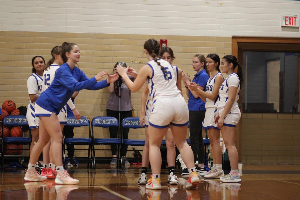 At the time, junior Sonya Petersen preforms her game-time ritual of crowing senior Lily Hobbs with senior Samantha Shreves during their game against the Travis Rebels on Dec. 20.