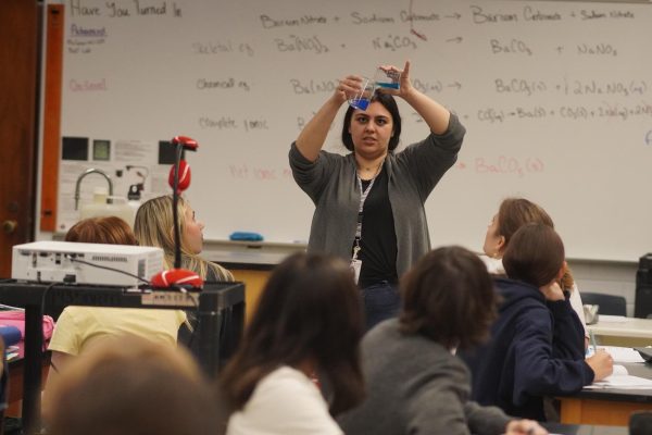 Antoinette Matthews demonstrates an experiment involving two liquids forming a precipitate to her first-period students.