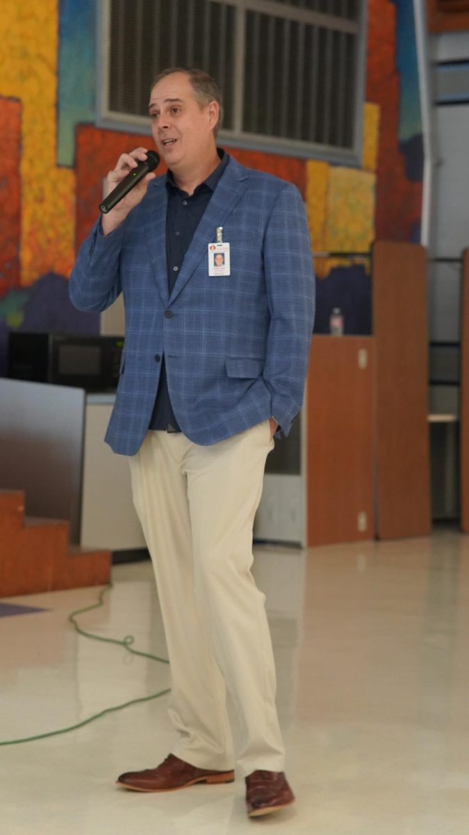 Principal Andy Baxa speaks at a meeting with McCallum parents and an AISD police officer last year.