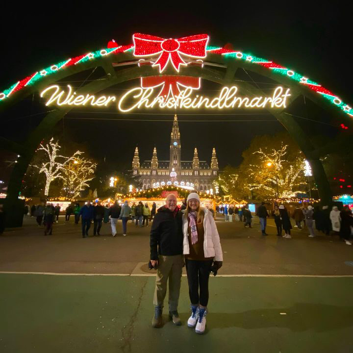 OH, VIENNA: While enjoying the Austrian leg of their European river cruise down the Danube River, English teacher Amy Smith and her husband Donald pose in front of the Christkindlmarkt at night in front of the Vienna town hall. “Vienna was gorgeous,” Smith told the Shield. “The Christmas market at night was magical.” The Smiths decided two years ago to book the vacation cruise that spans Thanksgiving break and the following week. “I figured I’d either retire and go or take the time off,” Smith said. “Baxa said, ‘Don’t retire.’” The river tour began in Budapest; after the stop in Vienna, the Smiths will take in Passau, Regensburg, Roth and Nuremberg in Germany and Prague in Czechoslovakia. Smith said the trip on AmaWaterways has exceeded her expectations so far. “The ship is amazing: gourmet meals and fancy service,” she said. “Every stop has been wonderful. It really is magical.” Caption by Dave Winter. Photo courtesy of Amy Smith.