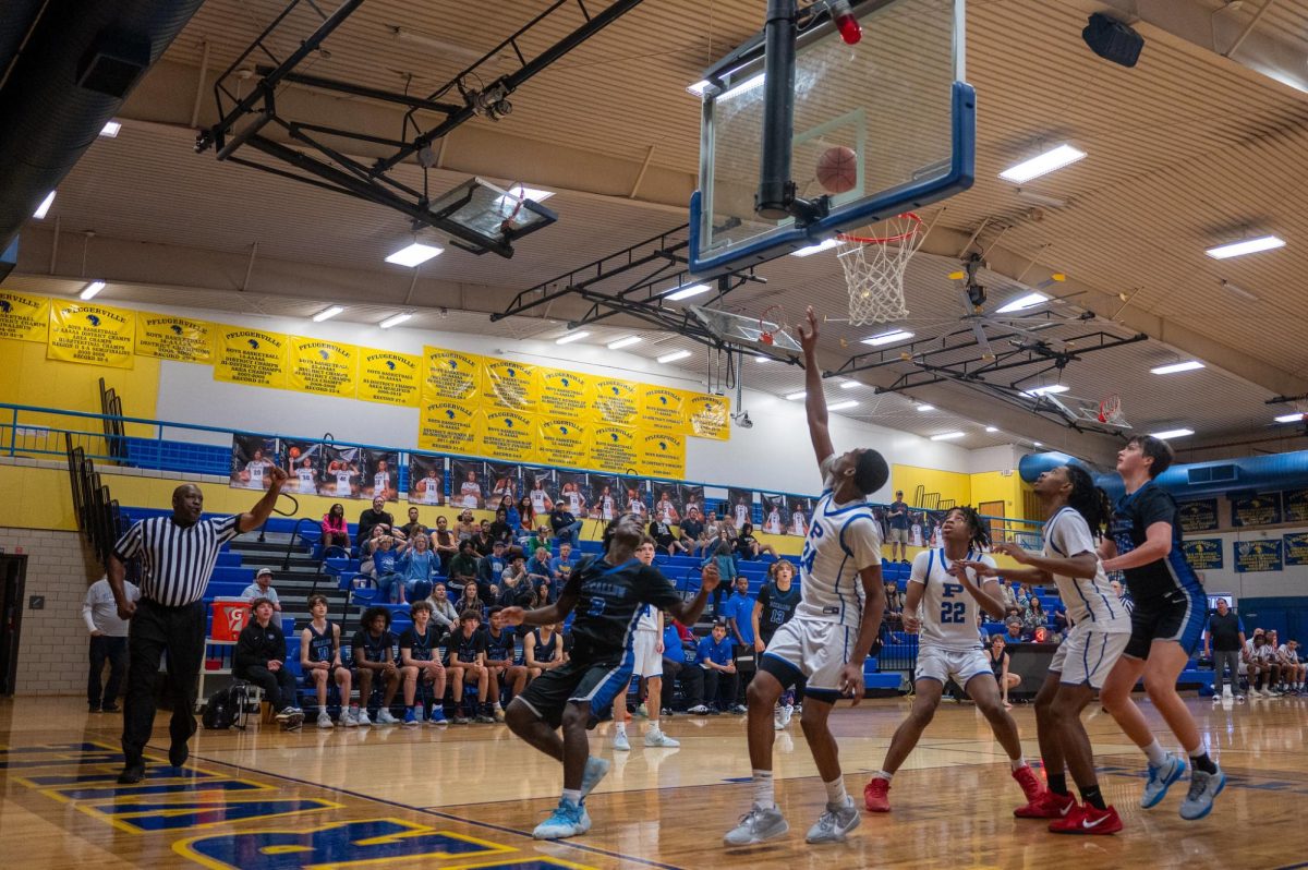 Senior Felix Kahlor watches and waits for his layup to fall through the basket on Saturday Dec. 28 against the Pflugerville Panthers. The game started with an almost immediate foul on the Knights, giving Pflugerville a quick two-point lead. By the end of the first quarter, however, McCallum had taken a 9-8 lead thanks to layups by junior Ethan Plummer, senior Luke Dunham and a three-pointer from senior George Brode.
The second quarter proved to be better offensively for the Knights, scoring 11 unanswered points to take a 20-8 lead at the half. Coming back from halftime, the Panthers took their turn and outscored the Knights 16-6, although McCallum still kept a two-point lead, 26-24, at the end of the quarter. Pflugerville didn't let up in the fourth quarter though, and once again outscored the Knights 15-12 to win the game 39-38.
Senior captain Felix Kahlor said that preventing turnovers and fouls are the main areas where the Knights could improve. 
"We need to do a better job at sticking with our game plan throughout the whole game and trusting each other more and just being more disciplined when we're playing offense and defense," Kahlor said.
Kahlor also noted that playing tougher teams in non-district, although sometimes resulting in a loss, will pay off eventually. 
"Playing more competitive teams will help us in the long run when we're playing tougher teams like Anderson and LASA." Kahlor said. "I think just doing this will really help us overall."
Caption by Julia Copas. Photo by Lucas Walker. 