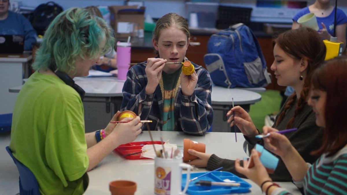 Members of the gardening club paint plant pots during a meeting on Nov. 14. Photo by Harper Maxwell. 