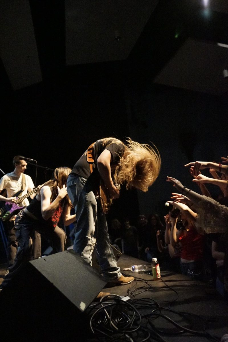 Junior Simon Welch rocks out on stage with his winning band MalaysiaBrunnei on Feb. 6 during his set for Battle of the Bands.