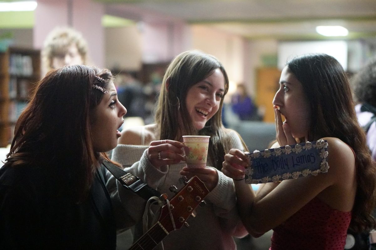 Junior Lexi Niles Arguello and her bandmates pose at the annual Coffeehouse event in the library on Feb. 14, hosted by the Excalibur staff. The event was held during fourth period, inviting writers and musicians to perform original pieces. Excalibur students put out many snacks for students to grab, including cupcakes, a fruit platter, tea and, of course, coffee. Niles Arguello's band, The Dolly Lamas, enjoyed their second performance in the band's history at Coffeehouse. Photo by Sophia Manos. 