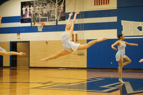 Junior Paige Mitchell leaps during group performance for Blue Brigade's annual show-off held last Wednesday commencing the contest season. 