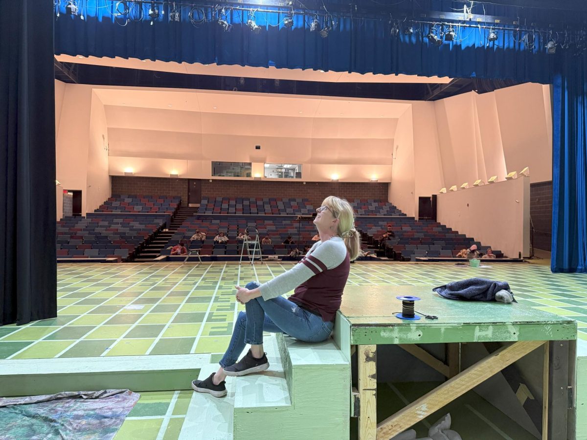 Tech theatre teacher Kristen Vandenberg poses for a portrait on the McCallum Arts Center stage, a space that she brings to life with every Mac Theatre show she supports with costumes, lighting, stage sets, props and more.