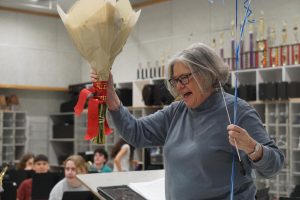 Carol Nelson raises the laurels she received from district officials after they invaded the band hall during sixth period to inform her that she had won the inaugural Austin ISD Icon Award