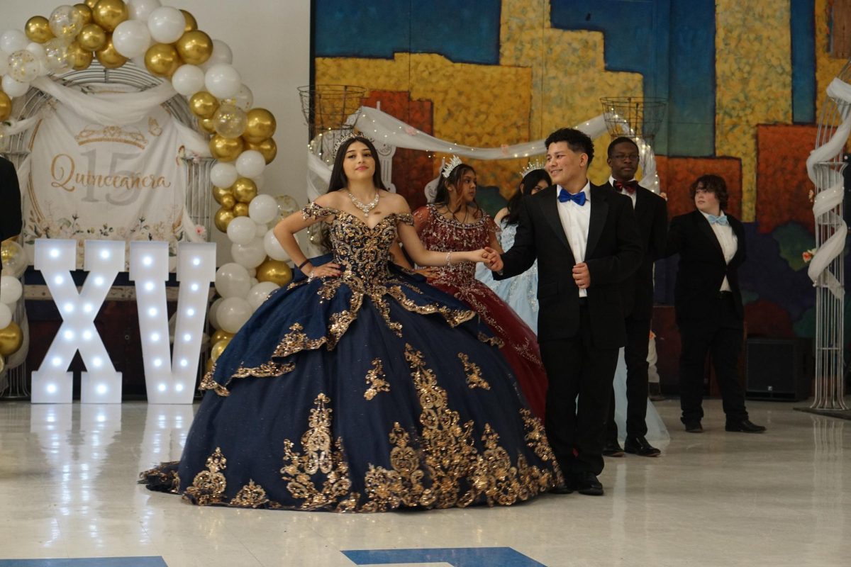 DRESS TO IMPRESS: Junior Sofia Arredondo-Nunez is introduced at the quinceañera, accompanied by sophomore José Yemez.  Arredondo-Nunez said she choose to be part of the event in order to embrace her culture.

“I decided to participate in the quinceañera because I wanted to build community and show Hispanic culture,” Arredondo-Nunez said. “Having a quinceañera is a special moment of entering womanhood. I loved the experience and thanked everyone for being there.”

Arredondo-Nunez said that she had a great time at the event, and that she is interested in being a part of the quinceañera again next year.

“I enjoyed all of us performing our dance and coming together as a friend group,” Arredondo-Nunez said. “I also enjoyed spending time with family. I am going to be joining next year's quince again. I loved getting to meet new people.”

Nunez said along with the quinceañera she is also interested in joining Ballet Folklórico.

“Getting to wear the clothes, makeup, and hairstyle seems fun,” Arredondo-Nunez said, “and it's a great way to embrace Hispanic culture.

Caption by Evelyn Jenkins.