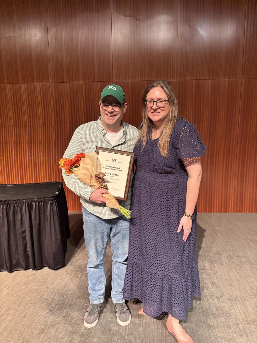 Shield adviser Dave Winter poses with his 2025 Max Haddick Texas Journalism Teacher of the Year Award and ILPC director Alyssa Boehringer, who presented Winter with the award at the ILPC Awards Ceremony on April 13 at the LBJ Auditorium.