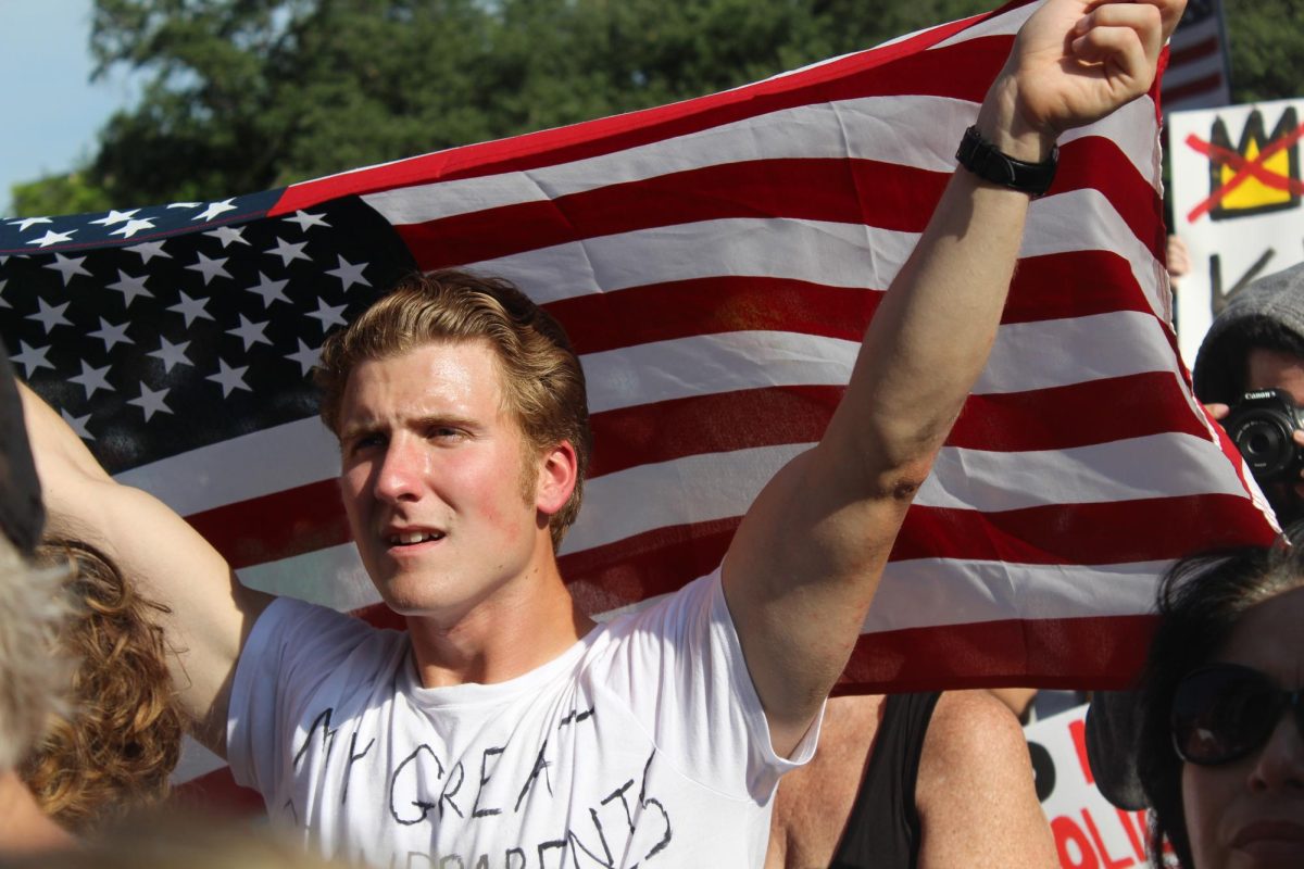 An unidentified protester holds an American flag aloft during the No Kings protest.