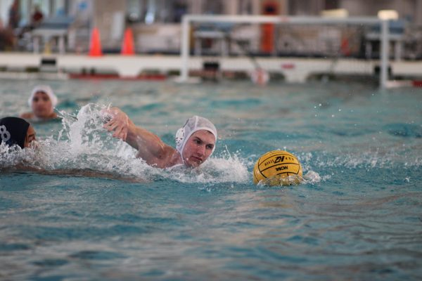 BEATING BOWIE: Senior Will Bowman swims towards the ball, attempting to gain possession, in the first district tournament for water polo on Sep. 13. The Knights faced Austin High, Anderson, Bowie, and LASA, but Bowman’s favorite game was their victory over Bowie. 

“It was great,” Bowman said. “We knew going into the game we had a good shot, and we were able to deliver.”

Although Bowman wishes the Knights had beaten Bowie by a greater number of points, he enjoyed the consistency of the Knights’ performance.

“We didn’t crush them hard,” Bowman said. “But it’s fun when you’re actually playing and shooting goals and doing good.”

Bowman primarily plays point, covering the middle of the court and making long passes. He occasionally fills in at set. He acknowledges that while the position still feels difficult, he has greatly improved at it since freshman year, when he began playing water polo for the first time.

“When I was a freshman, I was a skinny little kid,” Bowman said. “I still am, but I know what I am doing, and it’s pretty satisfying.”

After playing water polo all four years in high school, Bowman will miss the sport when he goes to college next year.

“It’s a little unfortunate this is my last time playing because I don’t think I’m going to play in college,” Bowman said. “At least I’ll have memories of these four years.”

Bowman has one more opportunity to form more memories with the water polo team this Saturday, Sep. 27, at the second district tournament. If the team wins one game, they will advance to bi-districts which will take place on Oct. 6. Bowman hopes not only to make bi-districts but to make a run in the playoffs and believes that the team can as long as it plays consistently.

“As long as we’re making goals and hitting well, we should do good,” Bowman said.

Caption by Elizabeth Nation.
