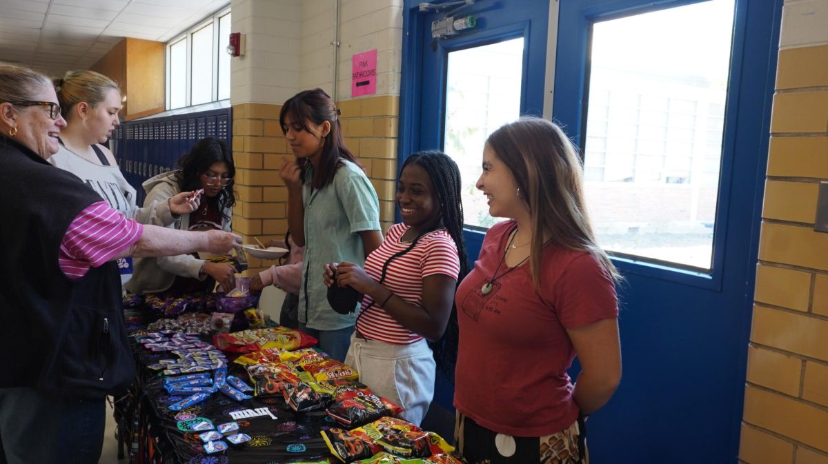 CELEBRATING CULTURE: During the Student of Color Alliance’s Hispanic Heritage Month fundraiser, junior Tegan Hahn helped lead the event by organizing volunteers, managing sign-ups, and selling traditional Hispanic snacks during lunch. As SOCA’s secretary, Hahn played a key role in planning the two-day sale.
 “I attended several SOCA meetings where we as a group collectively decided on what dates worked best for us,” she said. “Day of, I left class early to set up tables and snacks and then sold them during lunch.”
For Hahn, the fundraiser wasn’t just about selling treats, but sharing stories and building connections. 
“The treat-selling day is one of my favorite events SOCA does,” she said. “It’s cool to expose people to new foods and, in turn, teach them a little about a culture they’re not a part of.” 
Hahn added that events like this make McCallum feel more inclusive. 
“It’s super important to celebrate Hispanic Heritage Month because it provides educational opportunities for our community and helps marginalized groups feel seen. I love sharing my culture with others and learning about theirs, too.”
Caption by Mira Patel. 
