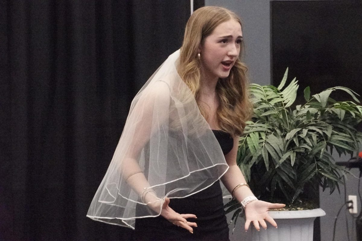 WARM WELCOME: Freshman Juliana Lotz performed her long prepared monologue on October 6th during the Freshman Theatre Showcase. During this year's showcase, Lotz highlighted that the amount of people cheering in the crowd was special to her and made her feel comfortable in her ability on stage. 

"I wasn't really that nervous after all,” Lotz said. “It was a very supportive space considering the turnout of the older theatre majors.”

In the past week, Lotz and other freshman theatre students were given one week of time to practice their monologues in class previous to the showcase. 

In her monologue, “Between the Lines,” Lotz mentioned she was very excited to perform in the play because it was challenging herself to exaggerate her act and fully pursue herself to the audience.

“I’ve always imagined myself wanting to go on and do acting at McCallum,” Lotz said. “My major takeaway is getting my timing down but I think that's honestly it.”

Caption by Ethan Roberts. Photo by Isadora Truan.