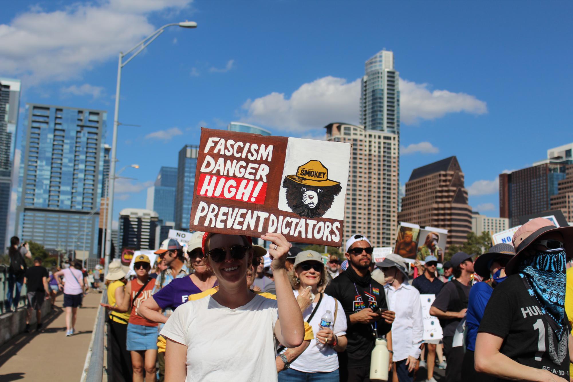 A protester holds a handmade anti-fascist sign featuring Smokey the Bear, a character that has been used by the U.S. Forest Service for wildfire prevention campaigns since 1944.