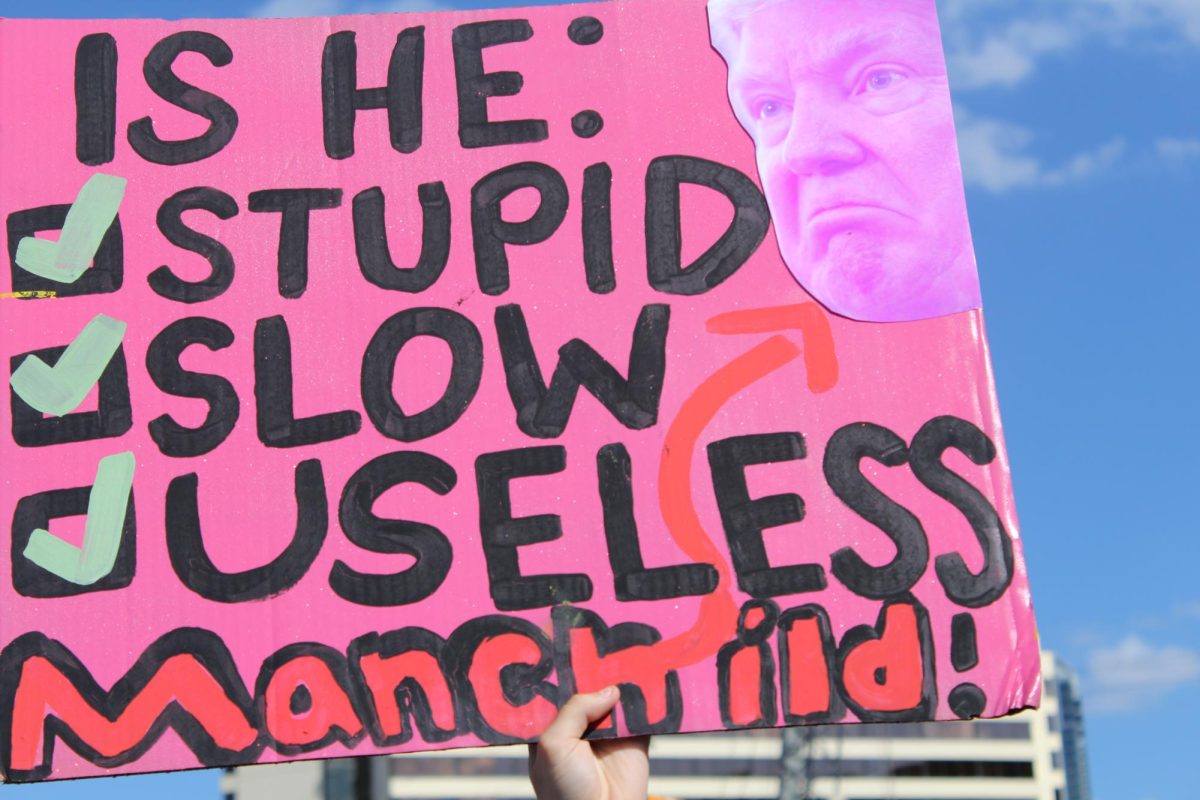 McCallum sophomore Hazel Wiggin holds up an anti-Trump sign referencing the song "Manchild," by Sabrina Carpenter, which lampoons the idea of weaponized incompetence.