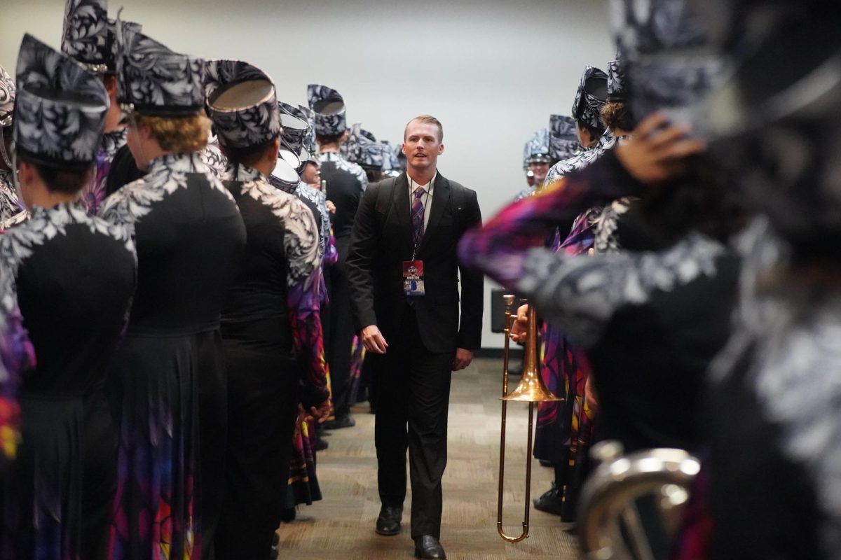 Assistant band director Dillon Junkin surveys the Mac Band before taking the field.