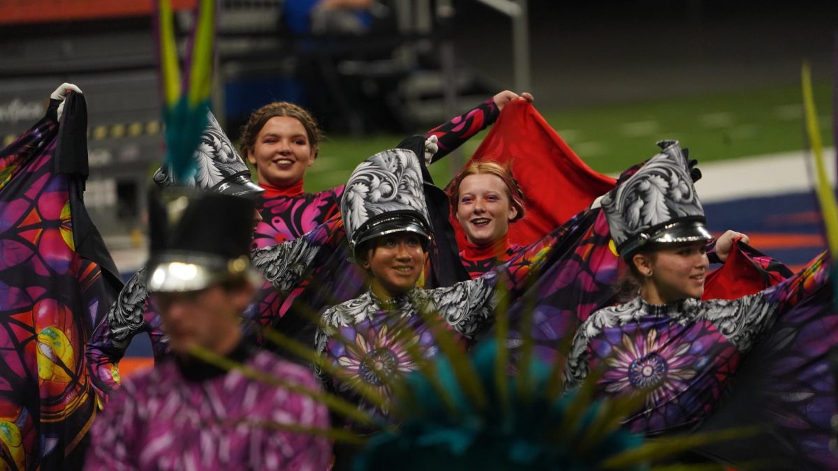 The McCallum drum majors and color guard captains celebrate after the announcement of their advancement to finals.