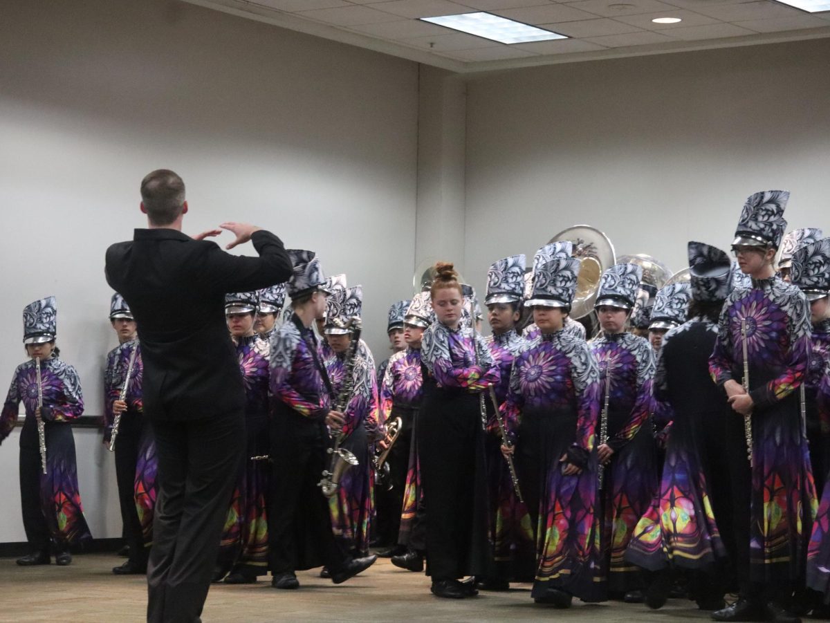 Band director Dillon Junkin talks to the band before practicing in the underbelly of the Alamodome. 