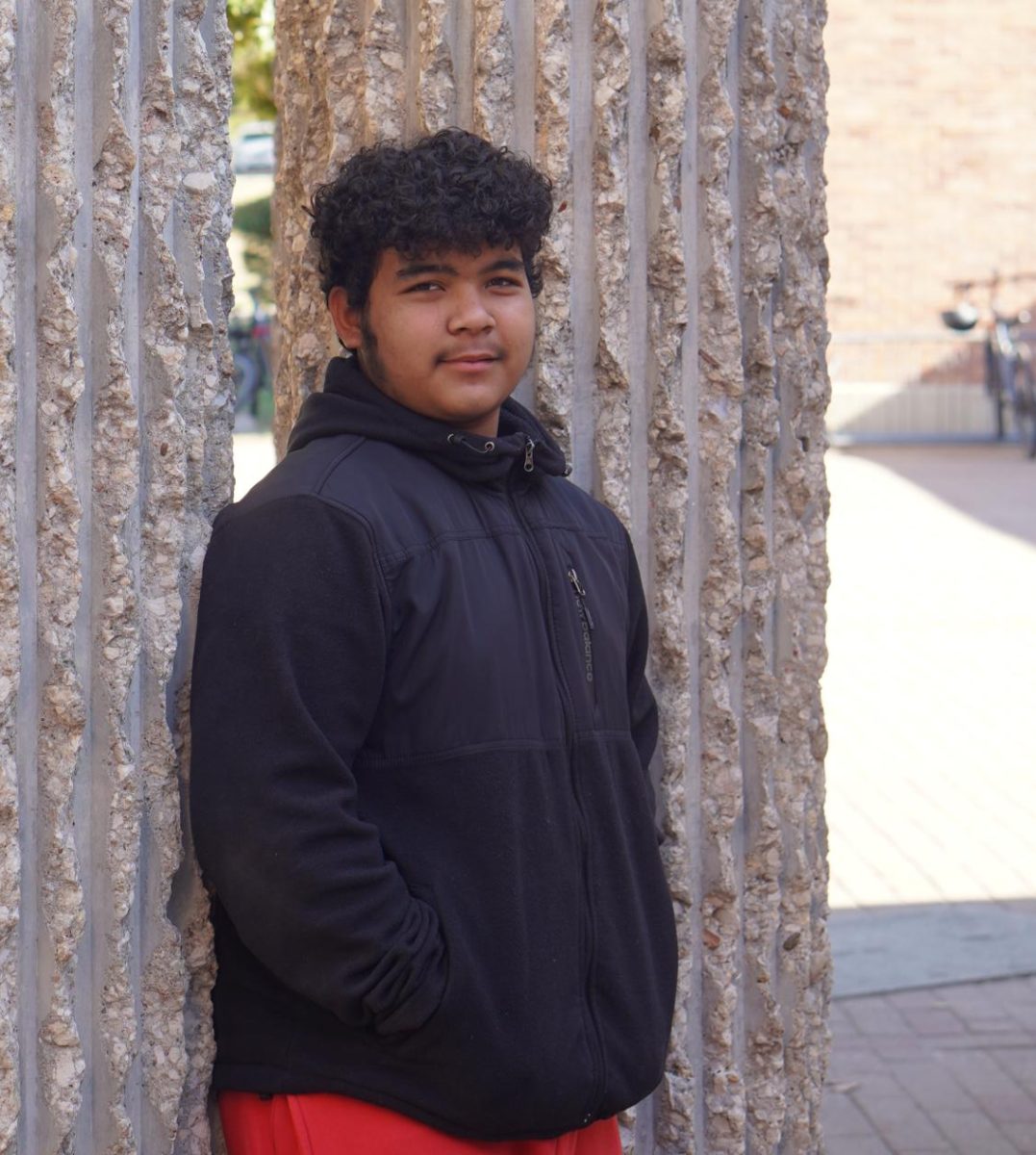 Photograph of Cristopher Maldonado Urbinas in front of the school by McCallum. 