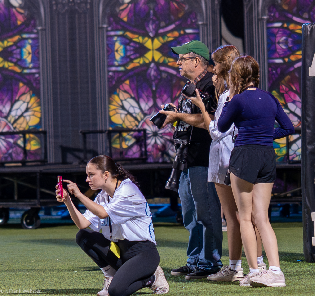 Former Newspaper Advisor, accompanied by current MacJ web managing editor Sophia Manos, and Yearbook editor in chief Emmerson Merrit, lines up the perfect shot during McCallum football game after being hired by the football booster club. 