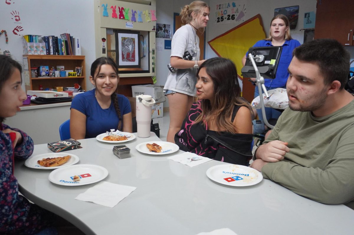 Jaxon [last name] and junior Lila Chilton pose during the Best Buddies Winter potluck Dec. 11. 