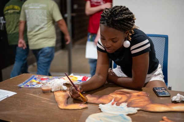 Senior Noble Pierce paints at the fine arts showcase on November 17th. 