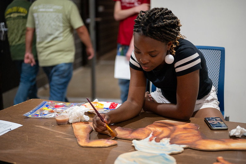 Senior Noble Pierce paints at the fine arts showcase on November 17th. 