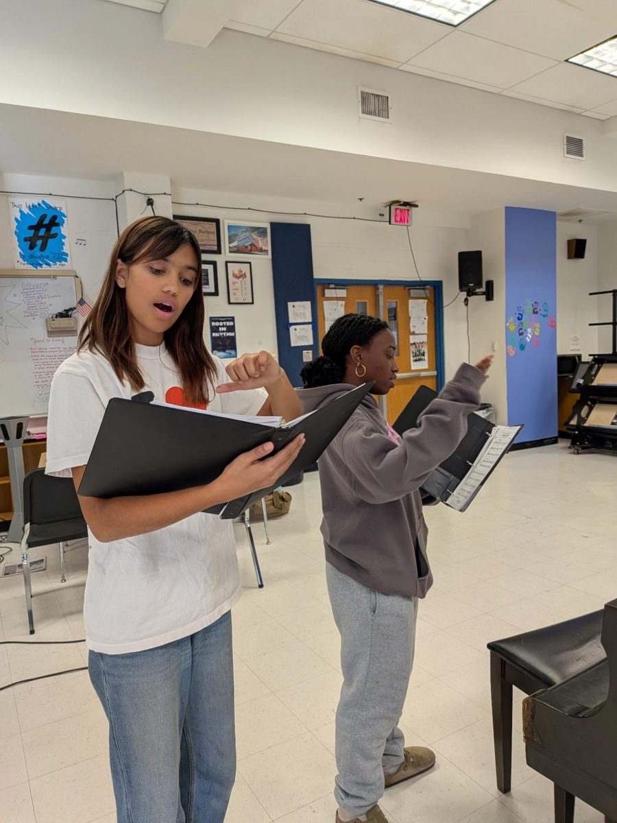 Show choir members Tegan Hahn and Paityn Jones sing in the choir room before the first show choir rehearsal.