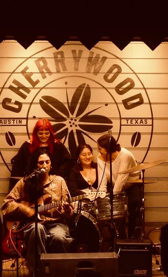 Senior Lexi Niles-Arguello performs a solo while surrounded by band mates seniors Emily Piper, Shirel Behar, and Annabelle Hamburger at Cherrywood Coffeehouse. 