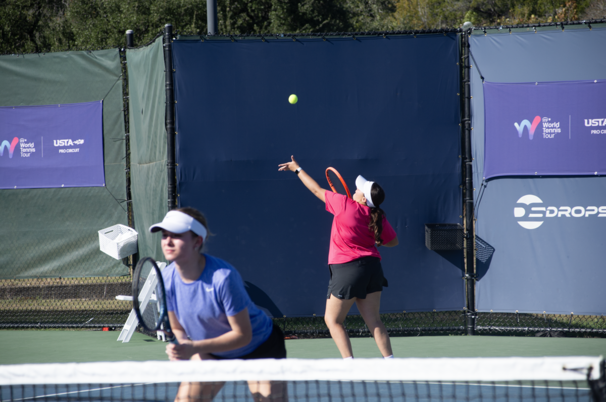 Senior Nadia Tissembaum serves while senior Elsie Smith guards the net at the first round of the W-50 Drop Shot Tennis Open on Nov. 12, 2025.