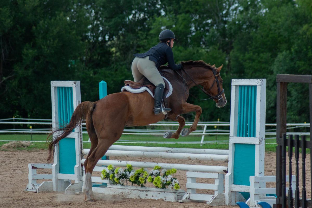 Junior Raquel Reichler-Cantero leaping over poles in a competition.