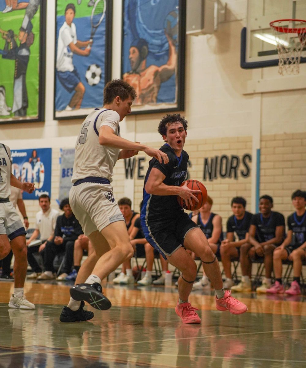 LASA player guards senior varsity boys basketball captain Ethan Plummer in the Knights' game against the Raptors on Feb. 17.