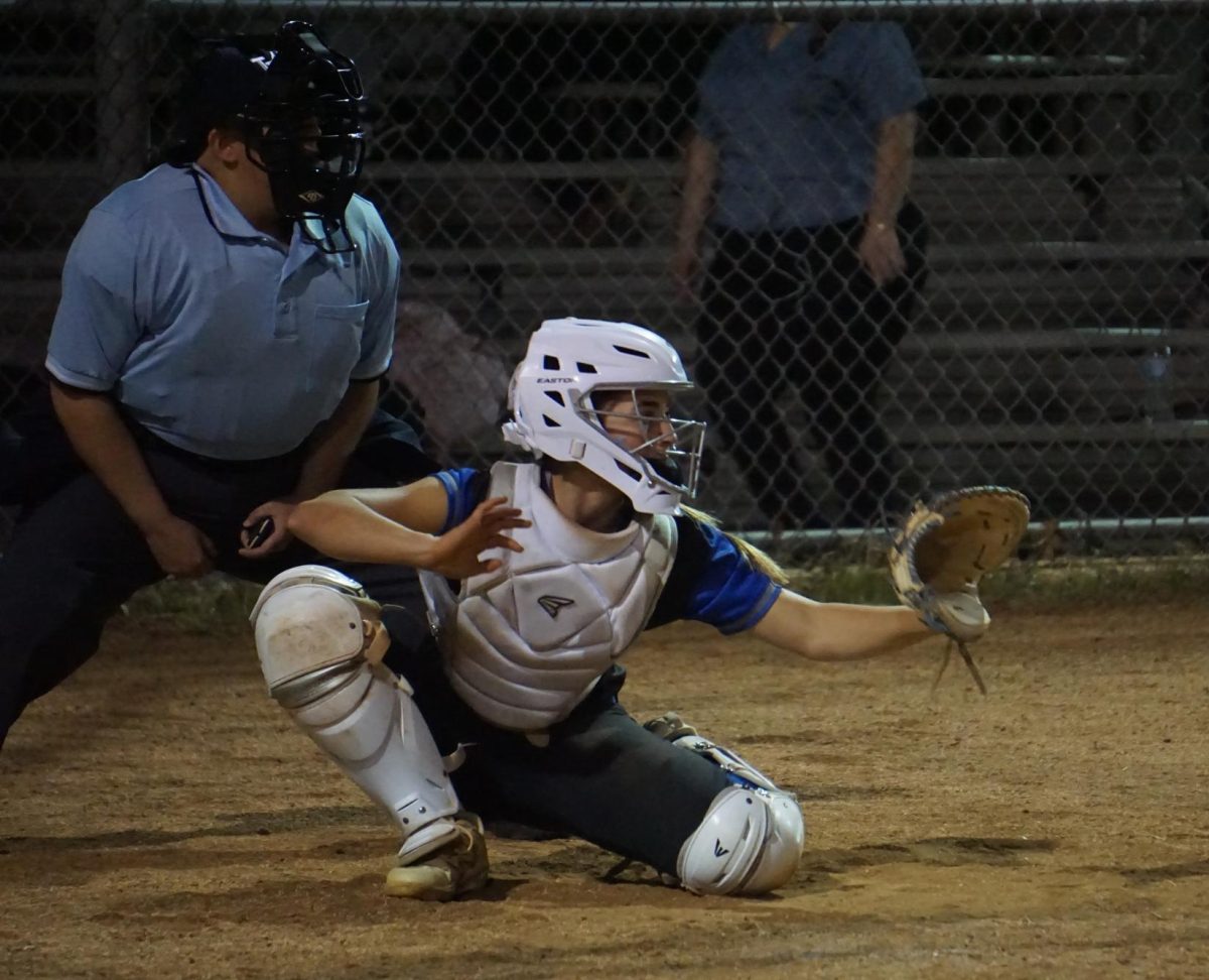 An umpire awaits the pitch as freshman Dot McColgin catches in a softball game. In the MLB, batters, pitchers and catchers now have ability to challenge an umpire's ball-strike call.