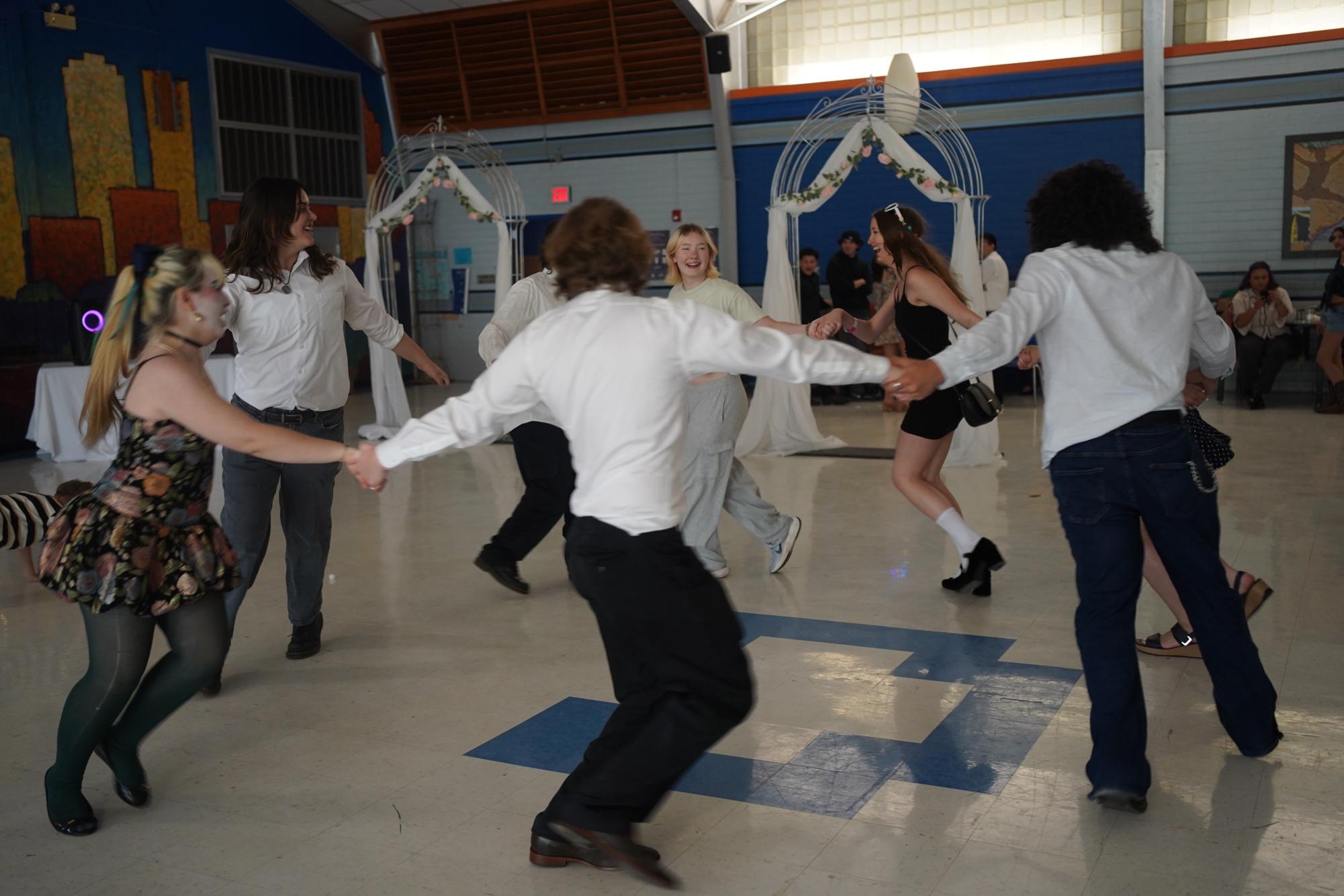 Guests at the Quince hold hands and dance in a circle.