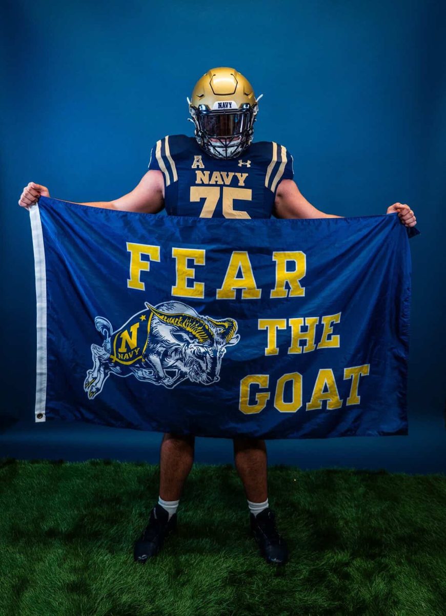Senior Dylan Fissel poses with the Navy flag during his official visit. Photo courtesy of Fissel.